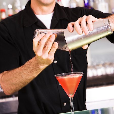 pouring cocktail shaker into glass - Bartender preparing a martini Stock Photo - Premium Royalty-Free, Code: 625-00837985