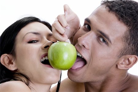 Portrait of a young couple sharing a green apple Stock Photo - Premium Royalty-Free, Code: 625-00838024