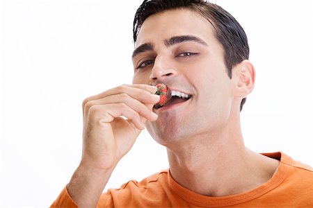 Portrait d'un homme adult moyen mange une fraise trempée au chocolat Photographie de stock - Premium Libres de Droits, Code: 625-00838034