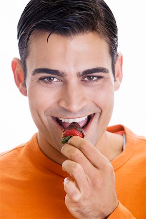 Portrait d'un homme adult moyen mange une fraise trempée au chocolat Photographie de stock - Premium Libres de Droits, Code: 625-00838037