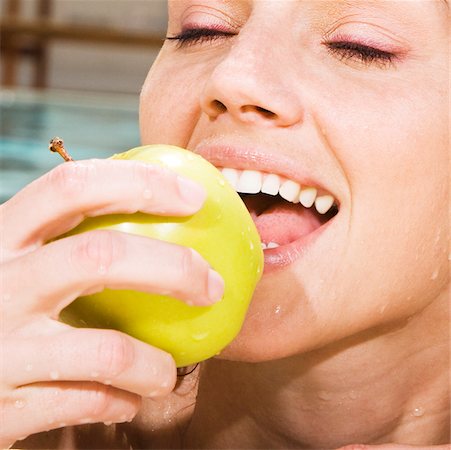 fruit eyes not children - Close-up of a young woman eating a green apple in a swimming pool Stock Photo - Premium Royalty-Free, Code: 625-00838050