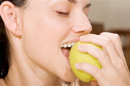fruit eyes not children - Close-up of a young woman eating a green apple Stock Photo - Premium Royalty-Free, Code: 625-00838053