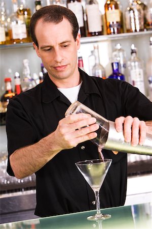 pouring cocktail shaker into glass - Bartender preparing a martini Stock Photo - Premium Royalty-Free, Code: 625-00838331