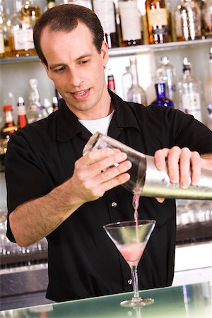 pouring cocktail shaker into glass - Bartender preparing a martini Stock Photo - Premium Royalty-Free, Code: 625-00838366