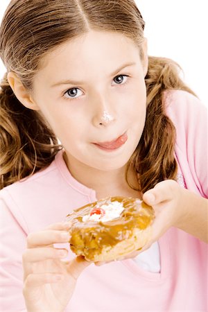 Portrait d'une jeune fille tenant un beignet lèche ses lèvres Photographie de stock - Premium Libres de Droits, Code: 625-00838605