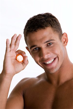 Portrait of a young man holding a condom Stock Photo - Premium Royalty-Free, Code: 625-00838701
