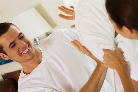 students friendly - Close-up of a young couple having a pillow fight Stock Photo - Premium Royalty-Free, Code: 625-00839076