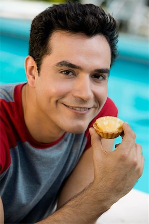 simsearch:625-01749029,k - Portrait of a young man holding a cupcake Stock Photo - Premium Royalty-Free, Code: 625-00849053