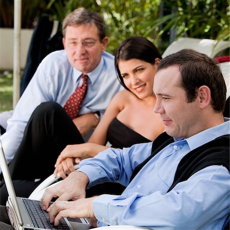 simsearch:625-00851478,k - Two businessmen and a businesswoman working on a laptop Stock Photo - Premium Royalty-Free, Code: 625-00849294