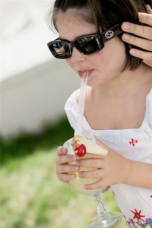 Close-up of a girl sipping drink from a glass Stock Photo - Premium Royalty-Free, Code: 625-00849530