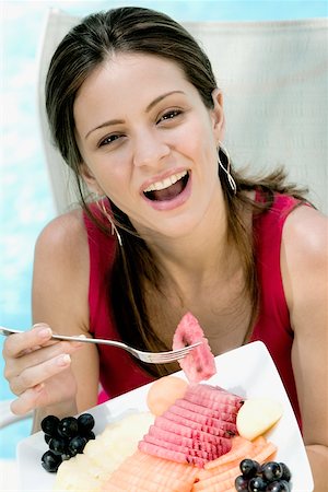 Portrait of a young woman eating fruit salad Stock Photo - Premium Royalty-Free, Code: 625-00849693