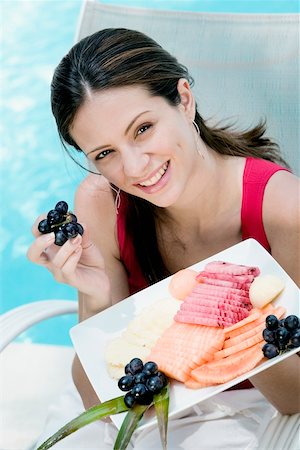Portrait of a young woman holding food in a tray Stock Photo - Premium Royalty-Free, Code: 625-00849797