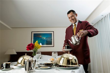 room service waiters uniforms - Waiter pouring tea in a cup Stock Photo - Premium Royalty-Free, Code: 625-00849854