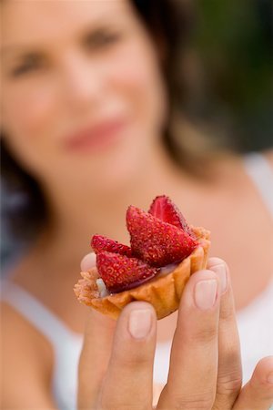 Close-up of a cupcake on a young woman's hand Stock Photo - Premium Royalty-Free, Code: 625-00849886