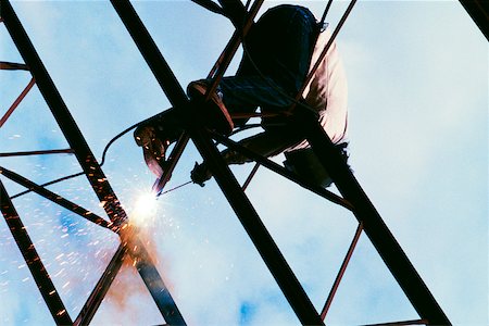Low angle view of a welder on a metal structure Stock Photo - Premium Royalty-Free, Code: 625-00840624