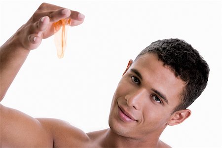Portrait of a young man holding a condom Stock Photo - Premium Royalty-Free, Code: 625-00841287