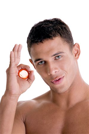 Portrait of a young man holding a condom Stock Photo - Premium Royalty-Free, Code: 625-00841288