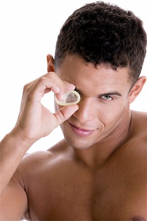 simsearch:625-01252359,k - Portrait of a young man looking through a condom Stock Photo - Premium Royalty-Free, Code: 625-00841295