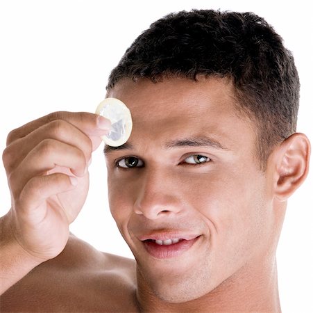 simsearch:625-00851085,k - Portrait of a young man holding a condom Foto de stock - Royalty Free Premium, Número: 625-00841296