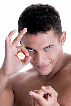 simsearch:625-00851085,k - Portrait of a young man holding a condom Foto de stock - Royalty Free Premium, Número: 625-00841290