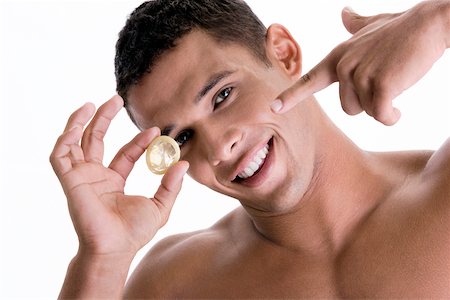 simsearch:625-00851085,k - Portrait of a young man pointing to a condom Foto de stock - Royalty Free Premium, Número: 625-00841293