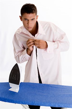 simsearch:625-00841323,k - Young man buttoning his shirt Stock Photo - Premium Royalty-Free, Code: 625-00841320