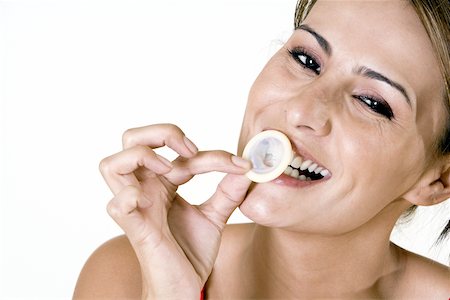 simsearch:625-00851085,k - Portrait of a mid adult woman biting a condom Foto de stock - Royalty Free Premium, Número: 625-00841352