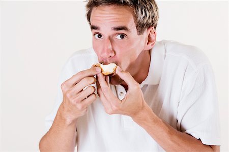 Portrait of a young man eating a strawberry tart Fotografie stock - Premium Royalty-Free, Codice: 625-00841379