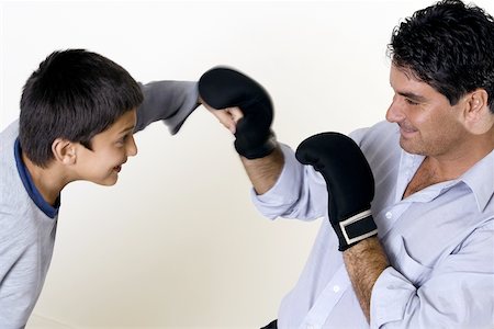 Close-up of a father and his son boxing Stock Photo - Premium Royalty-Free, Code: 625-00841473