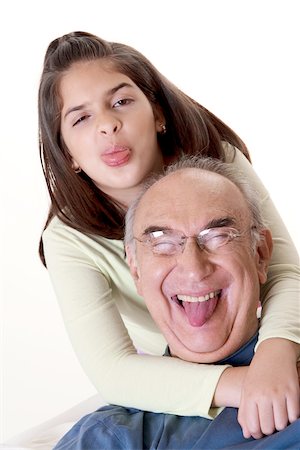 simsearch:625-00841593,k - Portrait of a granddaughter sticking out her tongue and hugging her grandfather Stock Photo - Premium Royalty-Free, Code: 625-00841604