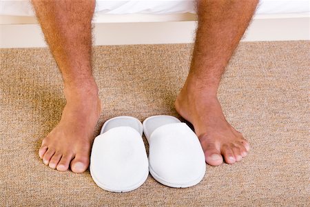 slippers man - Close-up of a man's feet near a pair of slippers Stock Photo - Premium Royalty-Free, Code: 625-00841803