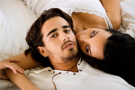double bedroom - Portrait d'un jeune homme couché avec une jeune femme sur le lit Photographie de stock - Premium Libres de Droits, Code: 625-00842343
