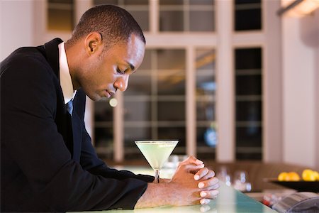 Side profile of a businessman with a glass of martini Stock Photo - Premium Royalty-Free, Code: 625-00842651