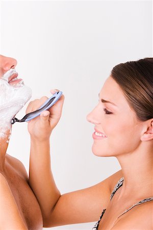shaving man woman - Side profile of a young woman shaving a mid adult man Stock Photo - Premium Royalty-Free, Code: 625-00842728
