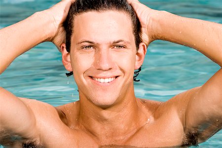 simsearch:625-01094790,k - Nahaufnahme eines jungen Mannes lächelnd mit den Händen hinter dem Kopf in einem Schwimmbad Stockbilder - Premium RF Lizenzfrei, Bildnummer: 625-00843448
