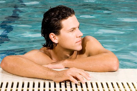 swimming pool leaning on edge - Close-up of a young man leaning at the edge of a swimming pool Stock Photo - Premium Royalty-Free, Code: 625-00843452