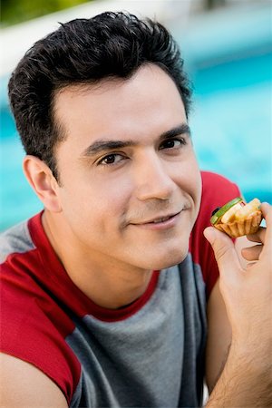 simsearch:625-01749029,k - Portrait of a young man holding a cupcake Stock Photo - Premium Royalty-Free, Code: 625-00850005