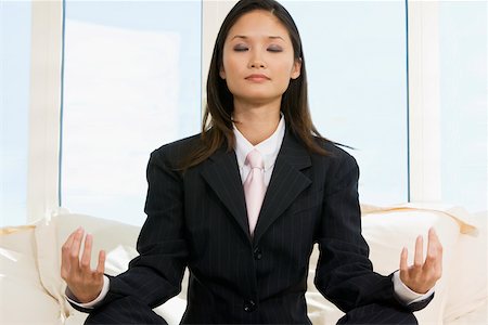 Close-up of a businesswoman sitting in the lotus position Stock Photo - Premium Royalty-Free, Code: 625-00850063