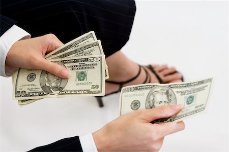 Close-up of a businesswoman giving a twenty dollar bill Fotografie stock - Premium Royalty-Free, Codice: 625-00850117