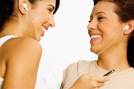 Close-up of two teenage girls listening to music with earphones Stock Photo - Premium Royalty-Free, Code: 625-00850118