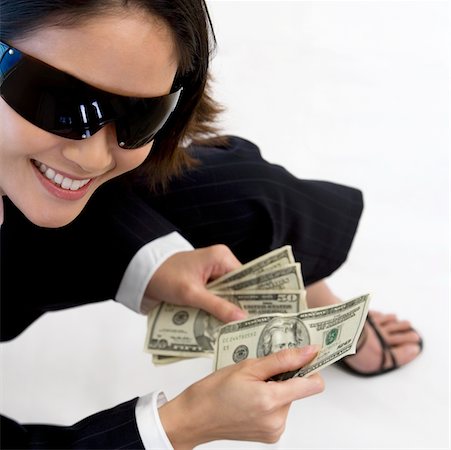 High angle view of a businesswoman holding American paper currency Fotografie stock - Premium Royalty-Free, Codice: 625-00850141