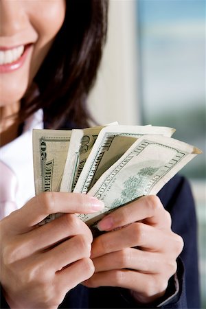 Close-up of a businesswoman holding American dollar bills Fotografie stock - Premium Royalty-Free, Codice: 625-00850191