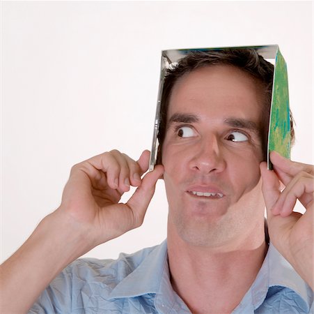 simsearch:625-00850090,k - Gros plan d'un homme adult moyen tenant une boîte de CD sur sa tête Photographie de stock - Premium Libres de Droits, Code: 625-00850259