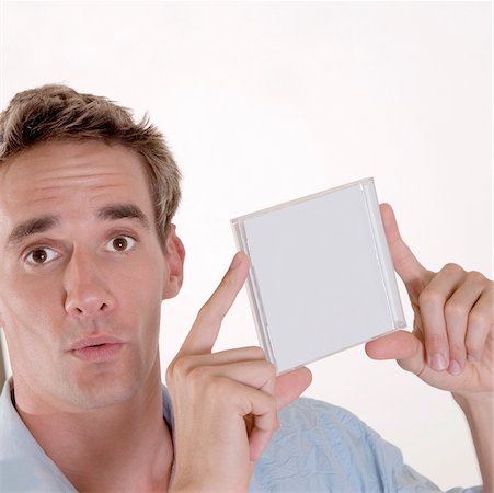 Portrait of a mid adult man holding a CD case Stock Photo - Premium Royalty-Free, Code: 625-00850407