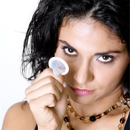 Portrait d'une jeune femme tenant un préservatif Photographie de stock - Premium Libres de Droits, Code: 625-00850475