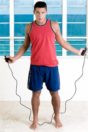 skipping ropes - Portrait of a young man standing with a jump rope Stock Photo - Premium Royalty-Free, Code: 625-00850479