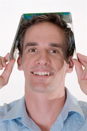 Portrait of a mid adult man holding a CD case on his head Stock Photo - Premium Royalty-Free, Code: 625-00850519