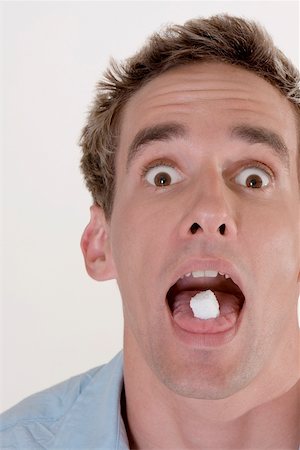 Portrait d'un jeune homme avec des bonbons dans la bouche Photographie de stock - Premium Libres de Droits, Code: 625-00850523