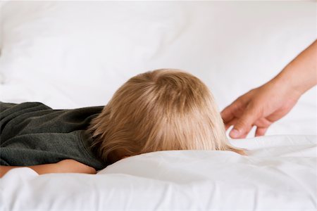 Boy sleeping on a bed Stock Photo - Premium Royalty-Free, Code: 625-00850539