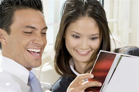 people laughing magazine - Close-up of a businessman and a businesswoman reading a magazine Stock Photo - Premium Royalty-Free, Code: 625-00850684